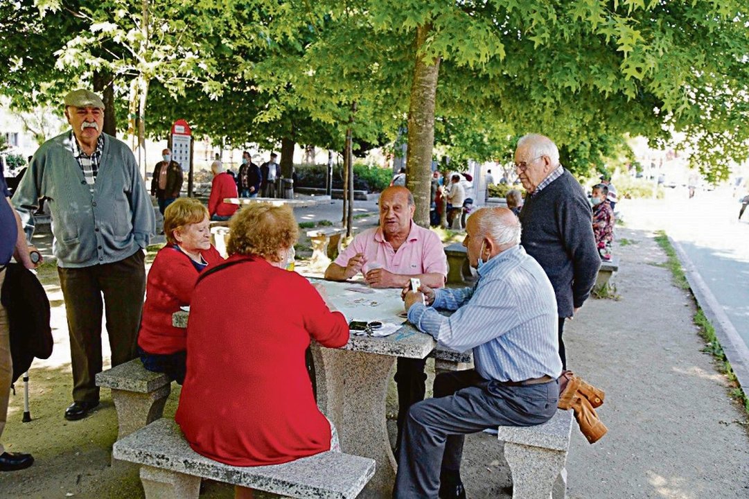 Un grupo de pensionistas juegan a las cartas en una zona de Coia.