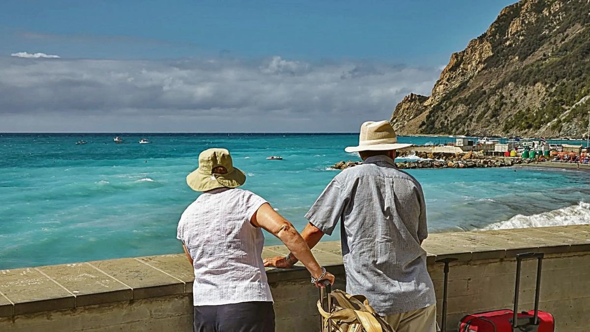 Dos turistas disfrutan de un paseo junto al mar.