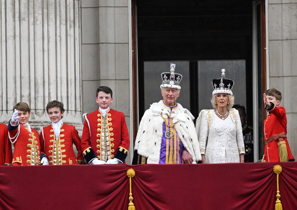El rey Carlos III y la reina consorte Camila en el balcón de Buckingham Palace con sus coronas. // EFE