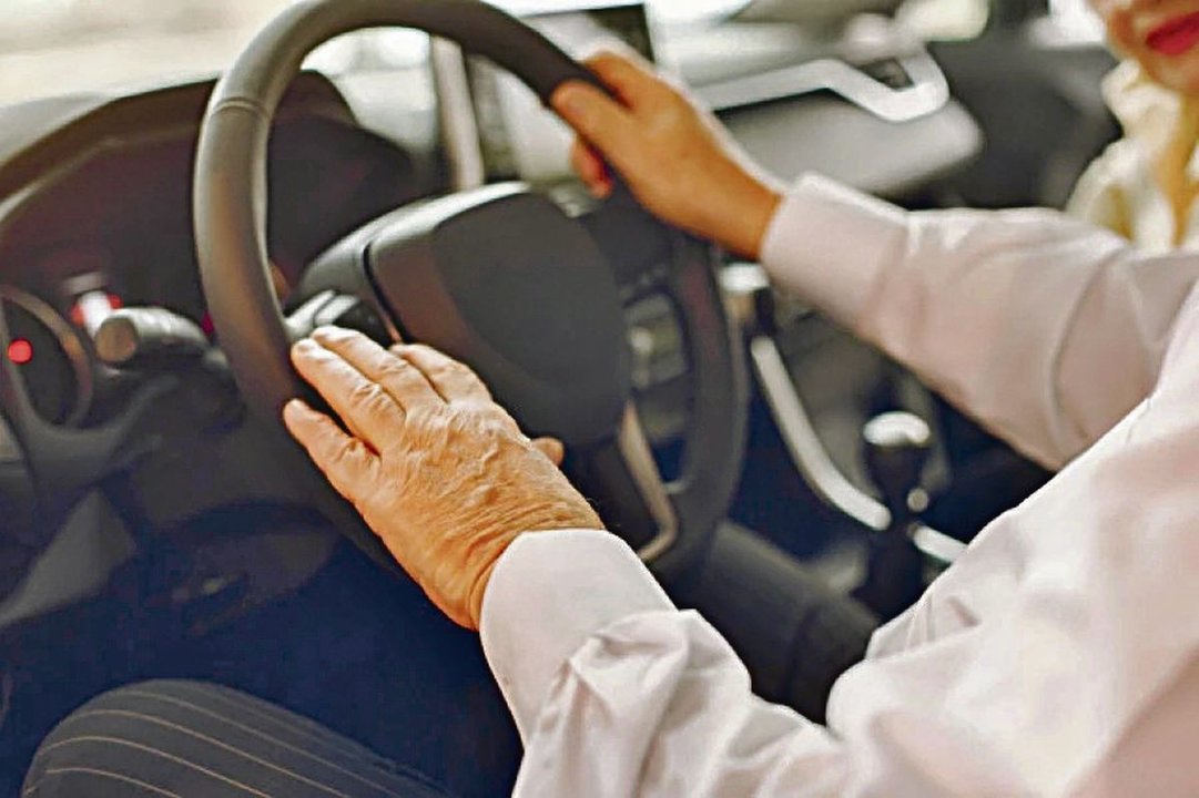 Una persona de edad avanzada al volante de un vehículo.