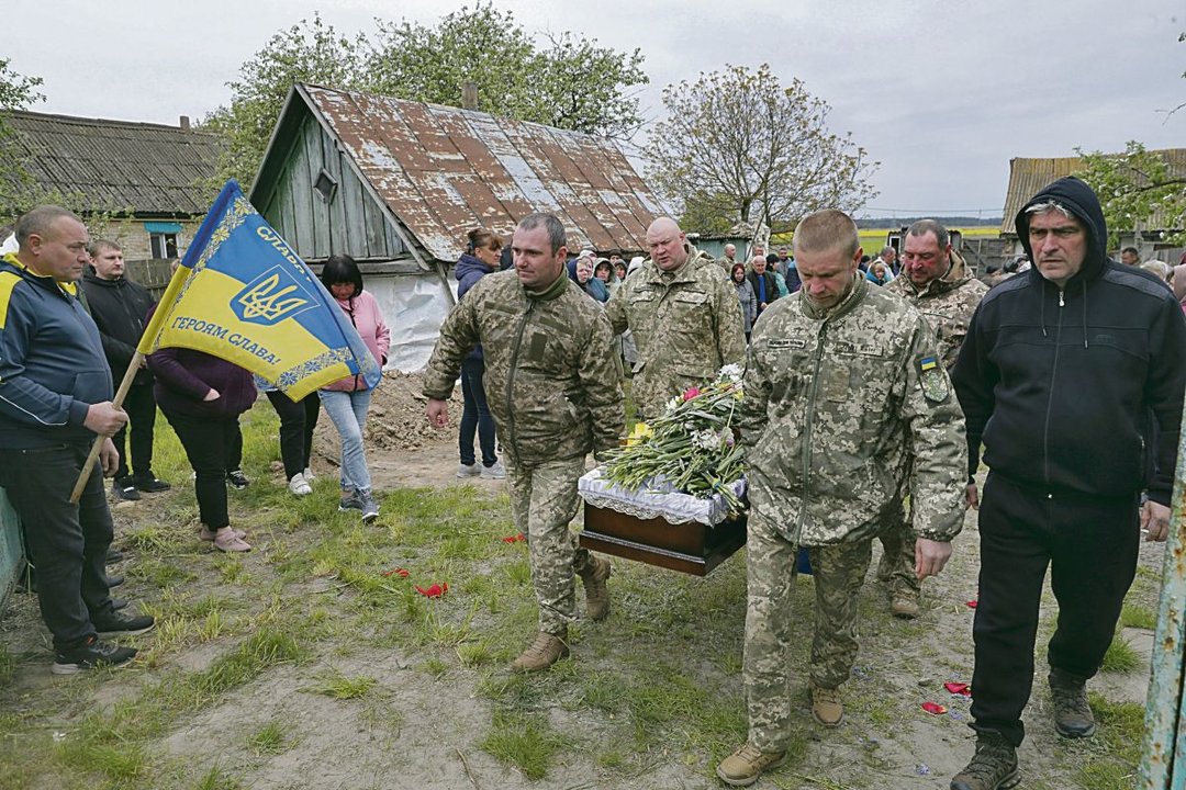 Camaradas del difunto militar ucraniano Mykola Shlyonsky llevan el ataúd durante su funeral.