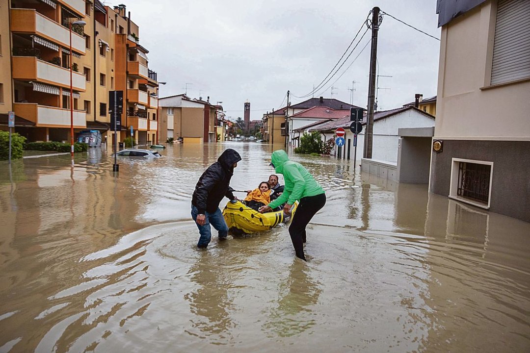 Un ciudadano con un kayak va y viene entre las casas inundadas de Cesena para salvar gente.