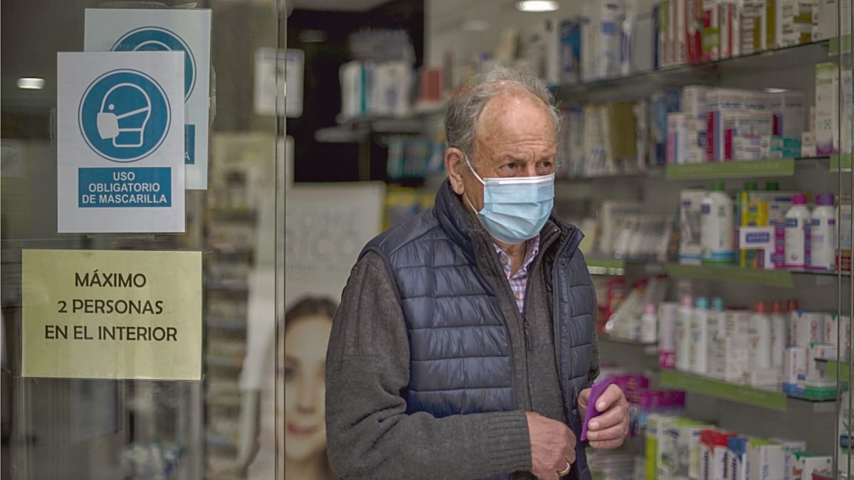 Un hombre sale de una farmacia con mascarilla en Ourense.