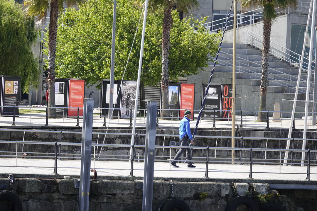 Un ciudadano paseando por la exposición en homenaje a Carlos Oroza instala en el puerto de Vigo. // Vicente Alonso