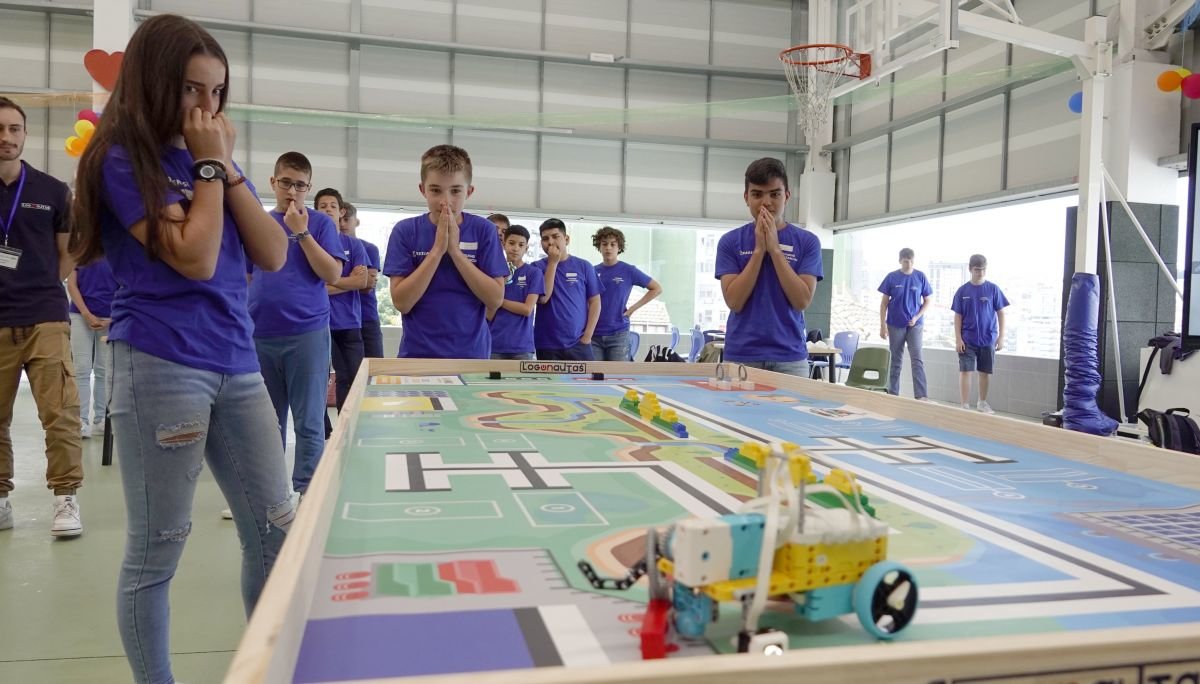 Un grupo de alumnos observa cómo va superando los obstáculos su robot autónomo.