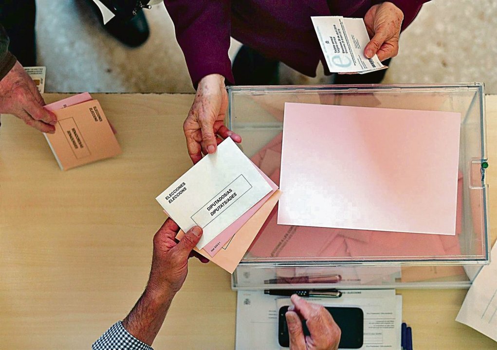 Una persona ejerce su derecho al voto en una urna.