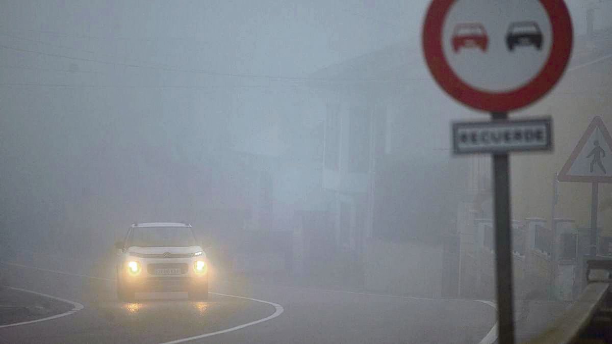 Un coche circula por la autovía A-8 con niebla densa, que dificulta la visibilidad.