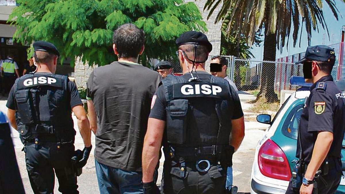 Dos agentes de la Policía portuguesa conducen a un detenido.