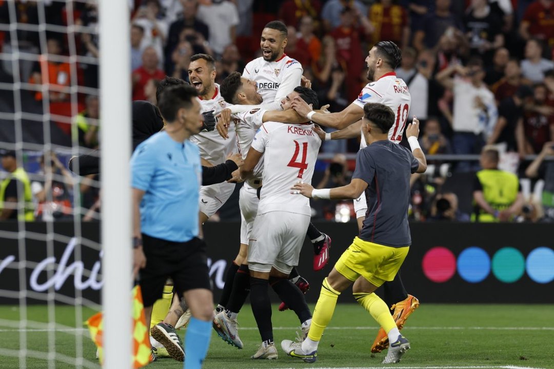 Los jugadores del Sevilla acuden a abrazar a Montiel tras el penalti decisivo.