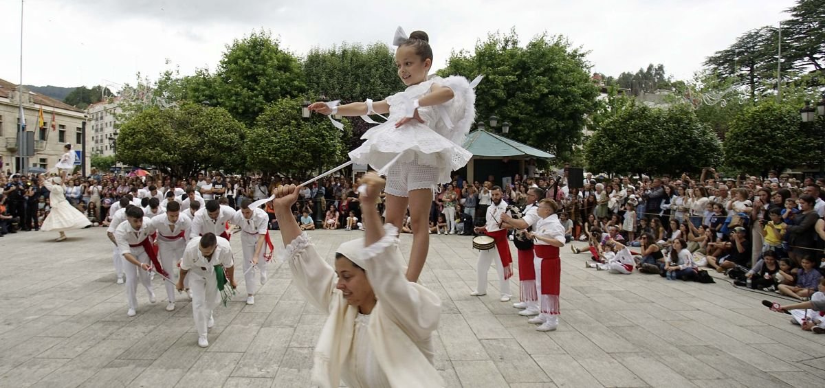 Una “burra” sostiene a una niña, las “penlas”, en el baile del Corpus en Redondela.