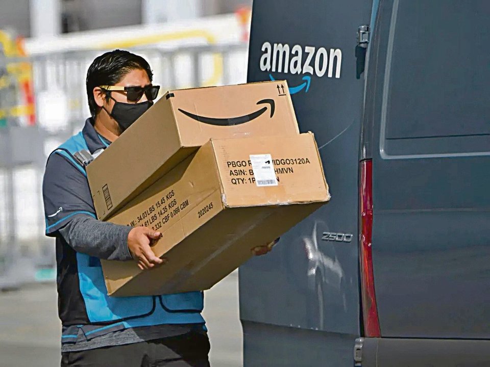 Un empleado de Amazon con paquetes para su reparto.