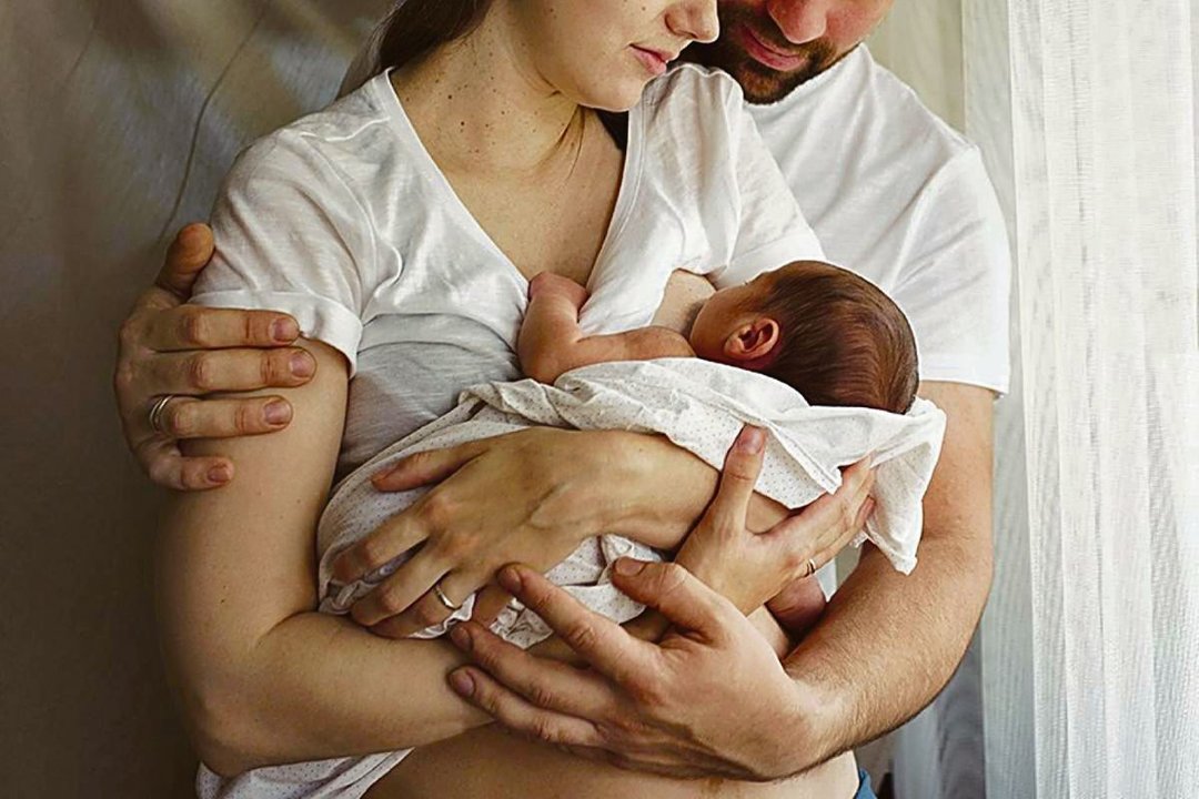 Una mujer le da el pecho a su bebé recién nacido.