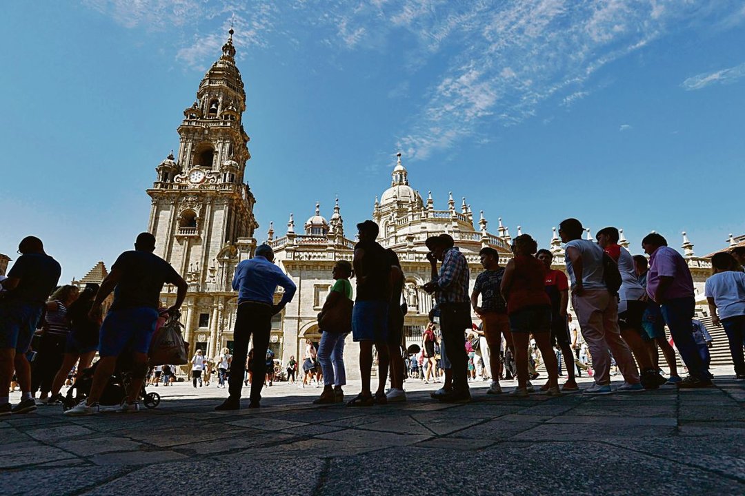 Peregrinos e turistas na praza do Obradoiro, epicentro cultural de Compostela.