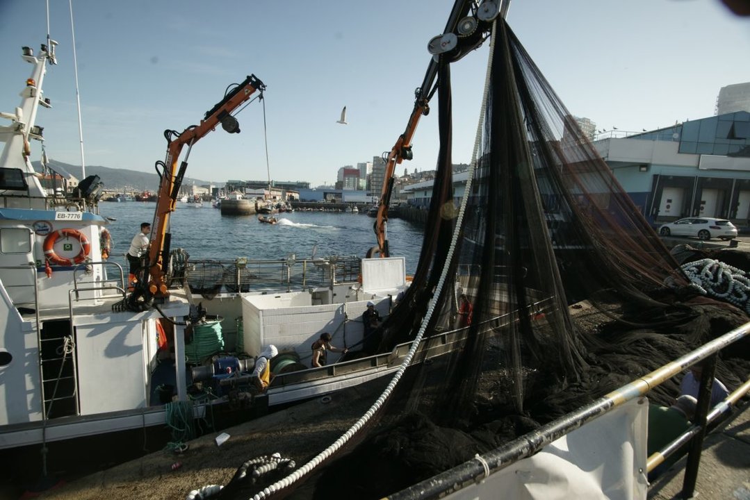 Un barco pesquero operando en la lonja del Berbés, la primera de Europa.