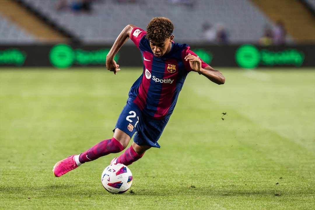 El joven futbolista Lamine Yamal conduce el balón durante un partido. // E.P.,