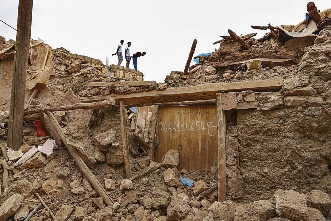 Varios jóvenes observan los edificios derruidos por el terremoto de Marruecos.