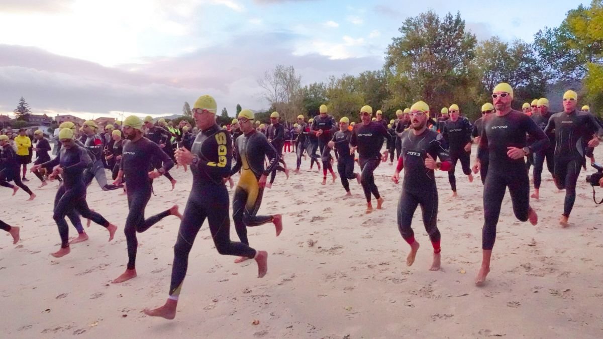 Competidores dirigiéndose al agua en la Playa de O Vao para realizar los dos kilómetros del sector a nado, primer tramo        de los tres en los que consistió el Triatlón Desafío Islas Cíes.