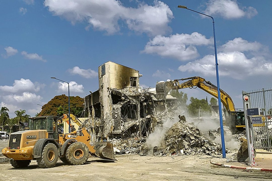 Dos excavadoras tiran abajo los restos de la estación de Policía de Sderot tras ser bombardeada.
