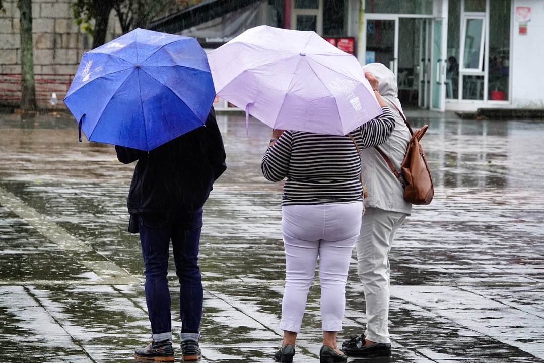 Un grupo de mujeres se protege de la lluvia. // Vicente Alonso