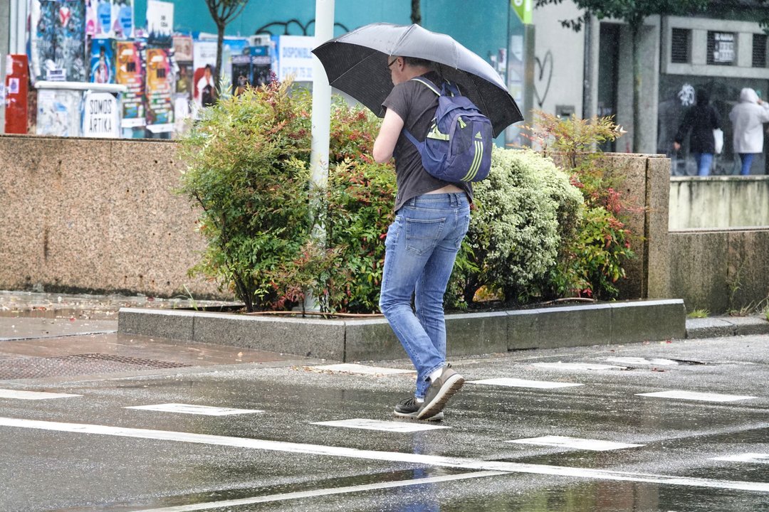 Un ciudadano se protege de la lluvia en Vigo con su paraguas.