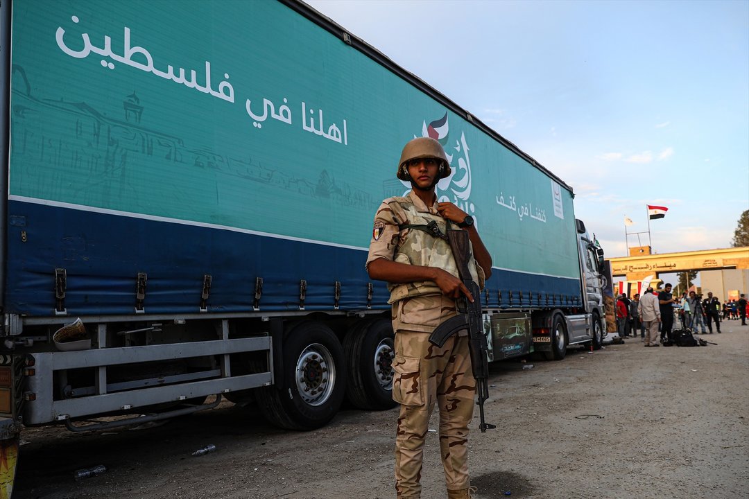 Un soldado hace guardia frente a un camión que transporta ayuda humanitaria cerca del lado egipcio del cruce de Rafá. // Europa press