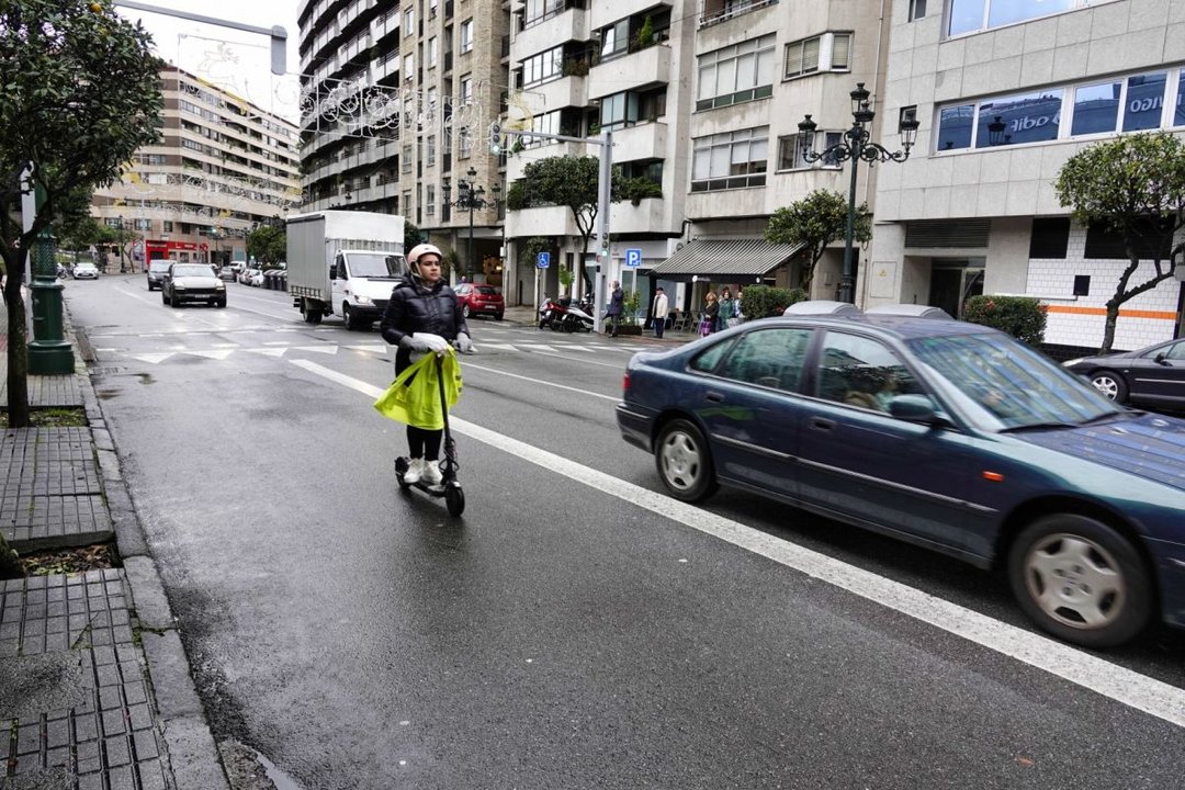 Una usuaria circula por el carril bici con un patinete eléctrico.