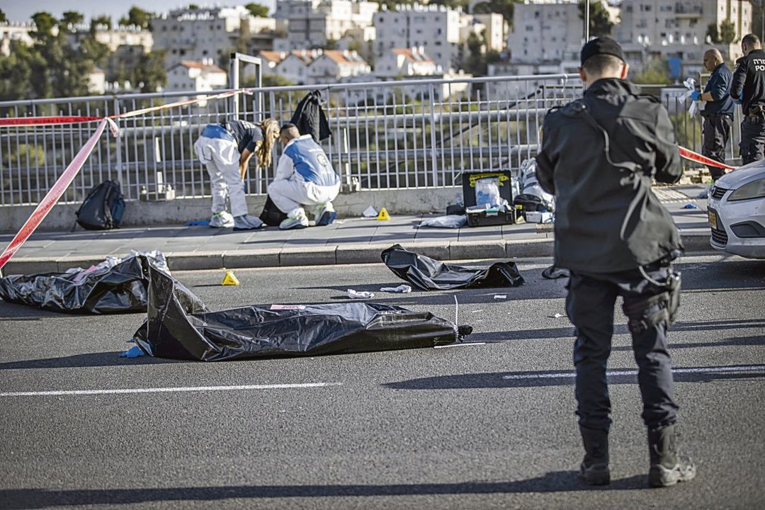Agentes e investigadores de la Policía, junto a los cadáveres, tras el ataque en Jerusalén.
