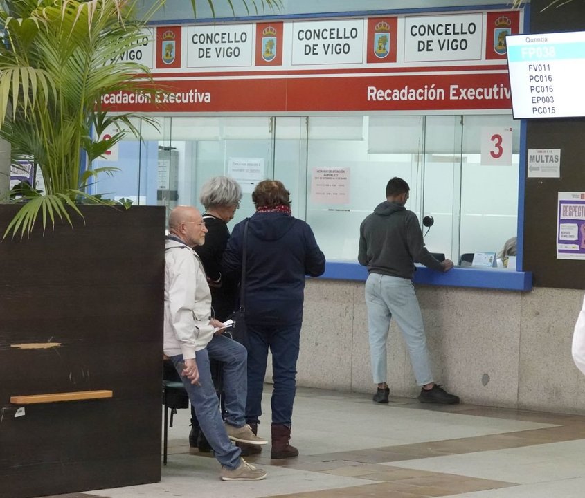 Vecinos realizando trámites tributarios en la lonja del Ayuntamiento de Vigo.