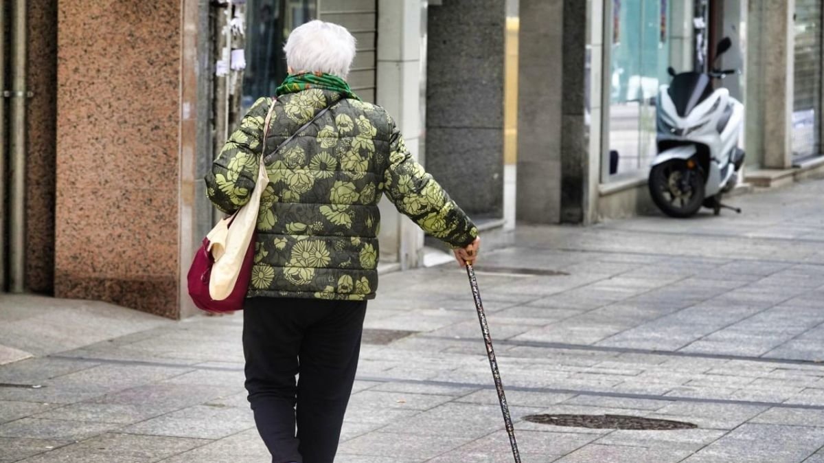 Una viguesa camina esta semana por una calle de la ciudad ayudada de un bastón.
