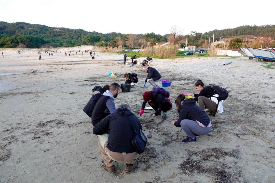 Un grupo de voluntarios rastreando ayer la playa canguesa de Nerga, donde aparecieron pellets.