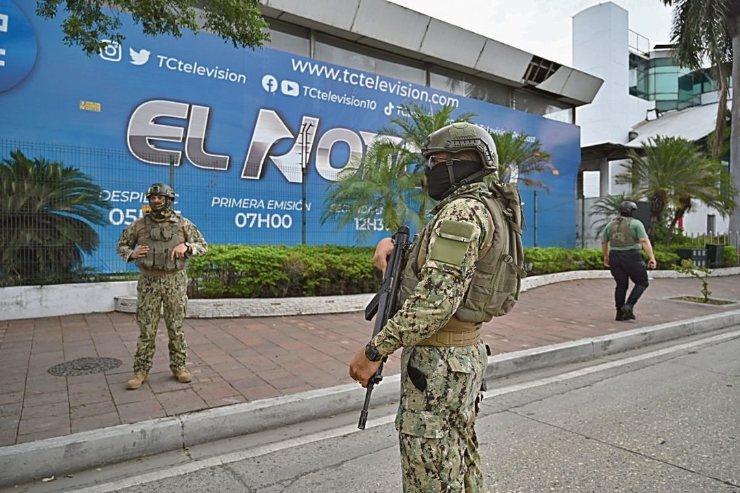 Dos soldados vigilan la sede del canal de televisión TC TV.