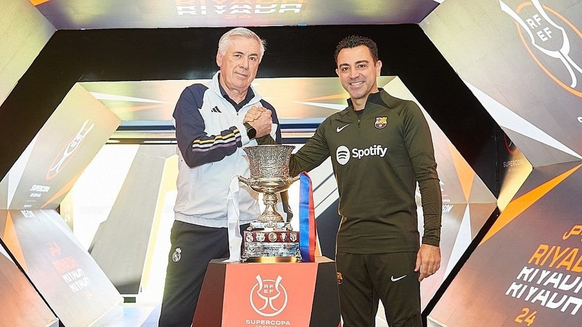 Los entrenadores Carlo Ancelotti y Xavi Hernández se saludan ayer ante el trofeo de la Supercopa.