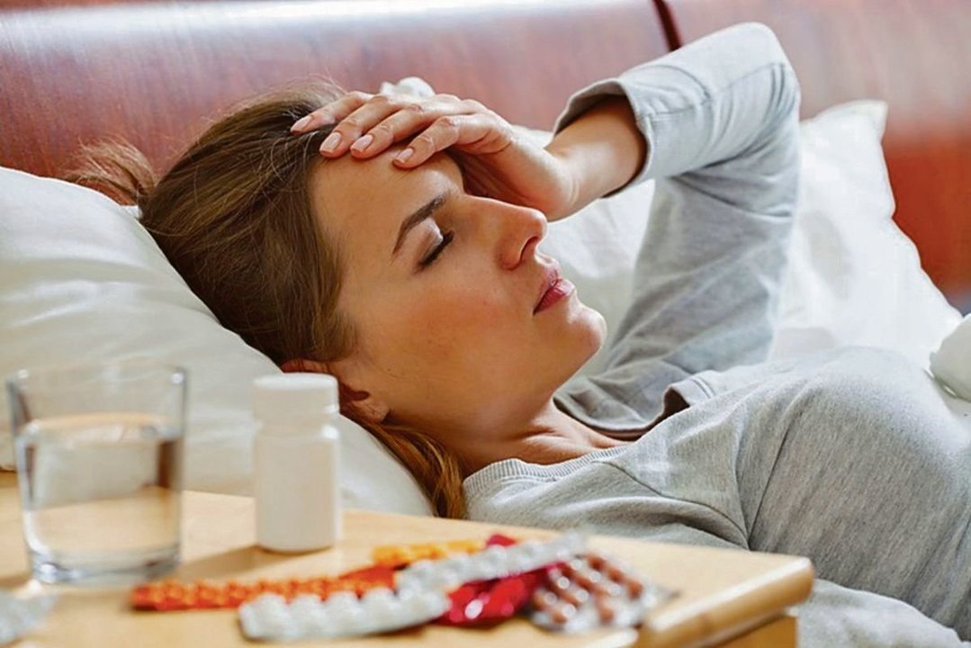 Una mujer sufriendo dolor de cabeza por culpa de la migraña.