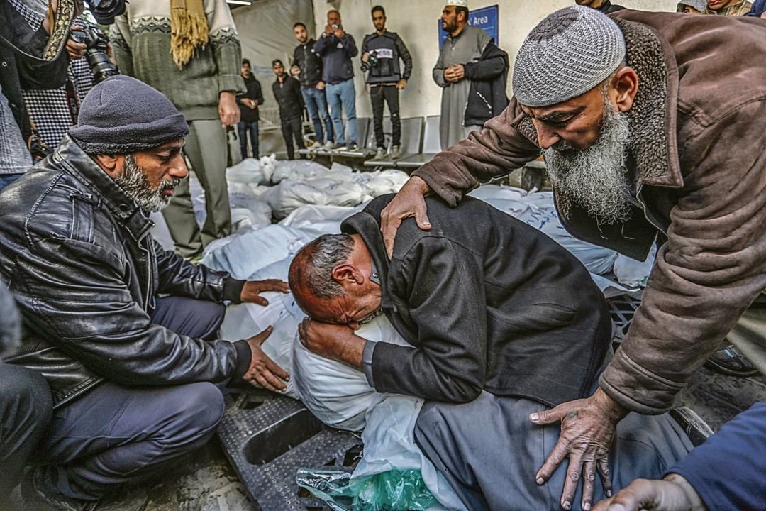 Un palestino llora sobre un grupo de cadáveres, el jueves en Rafah, al sur de la Franja.