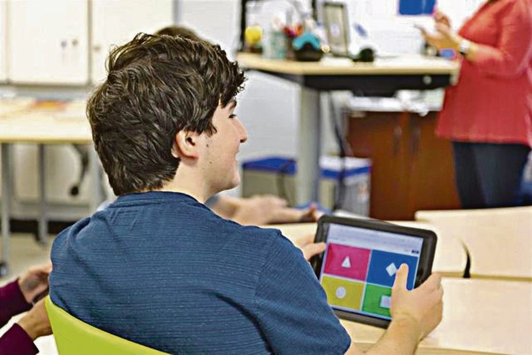 Un alumno utiliza su tablet en clase.
