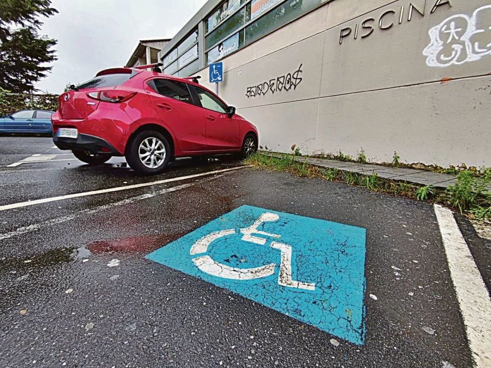 Una plaza de aparcamiento para personas con discapacidad junto a la piscina de Teis.