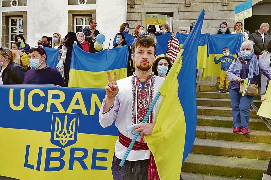 Un joven ucraniano con su traje nacional y la bandera, en un acto por la guerra.
