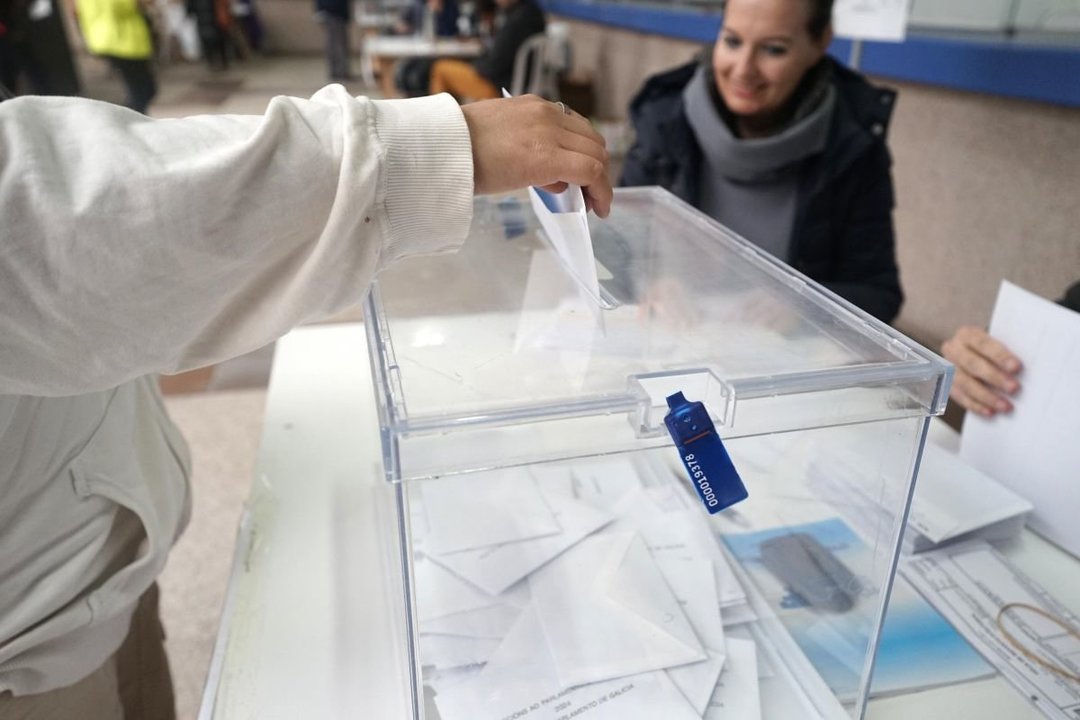 Un votante introduce su papeleta en la urna en un colegio electoral de Vigo el domingo.