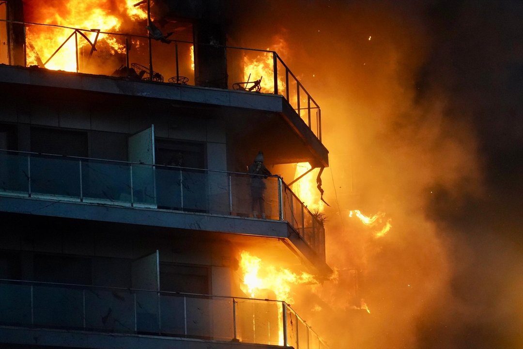 Una persona en un balcón del edificio en llamas de Valencia. // Europa Press