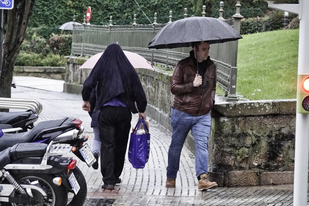 Jornada lluviosa en Vigo, cada uno se cubre como puede. // Vicente Alonso