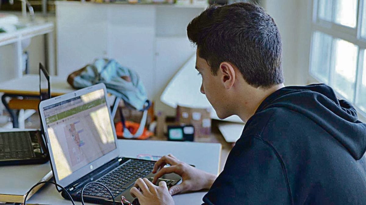Un joven consulta sus redes sociales en su ordenador portátil.