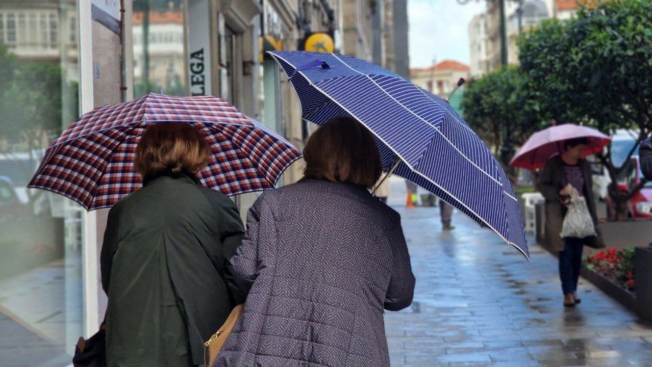 Dos mujeres se protegen de la lluvia. // J.V. Landín