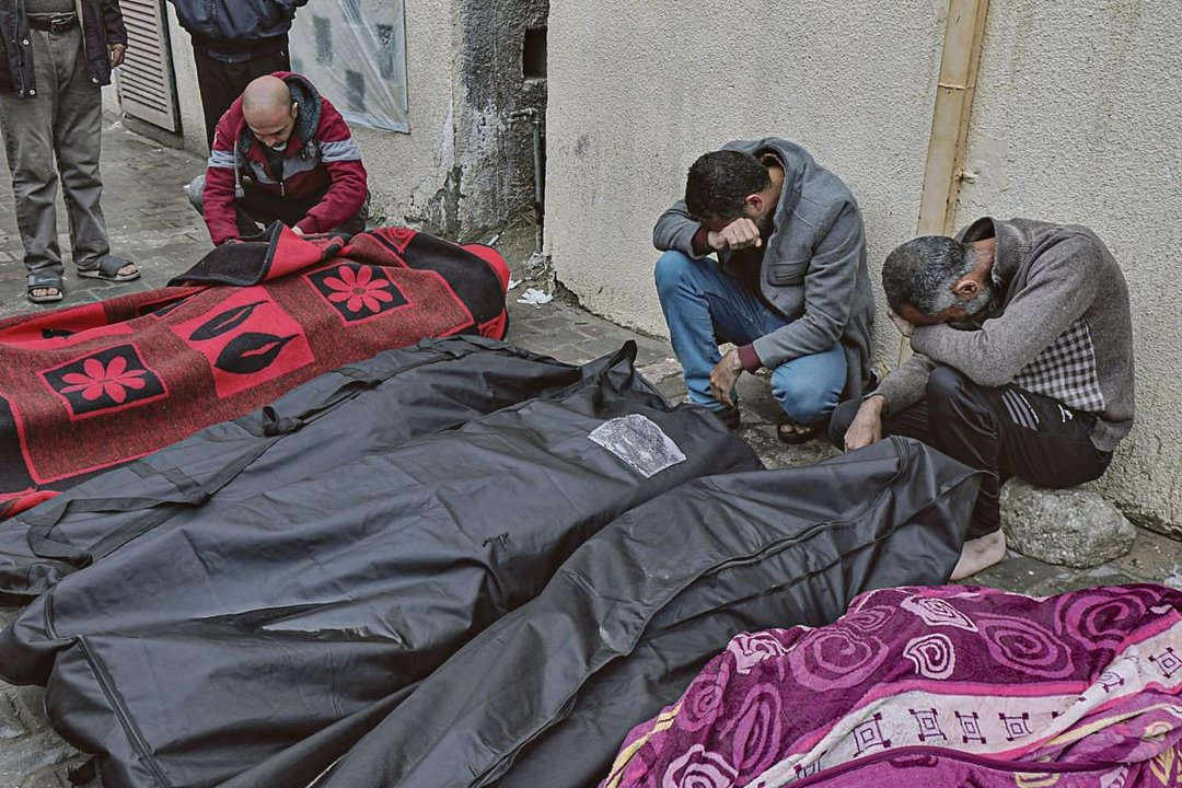 Familiares de palestinos que murieron en ataques israelíes lloran ante sus cadáveres.