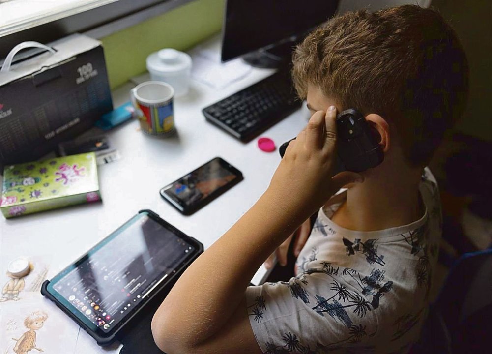 Un niño utilizando el teléfono móvil y una tablet.