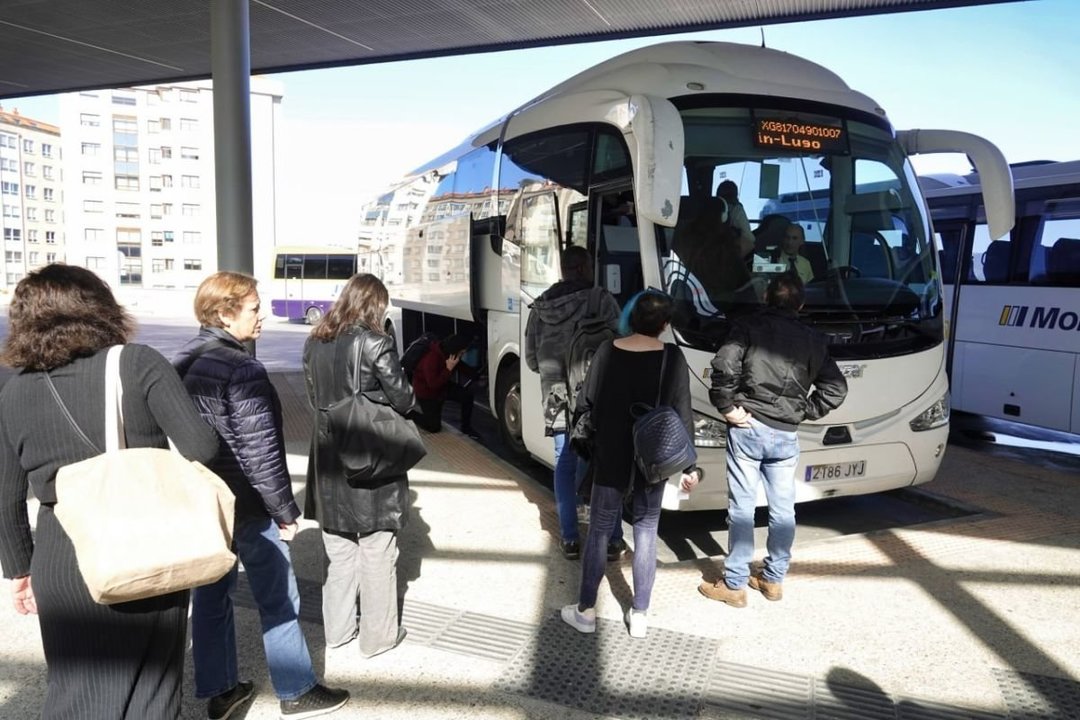 Usuarios hacen cola para subir en el bus con destino Lugo que salió ayer desde la estación de Urzaiz.