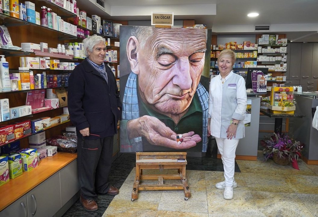 Xai Óscar y María Auxiliadora Villar presentaron el cuadro que se expone en la farmacia de O Progreso.
