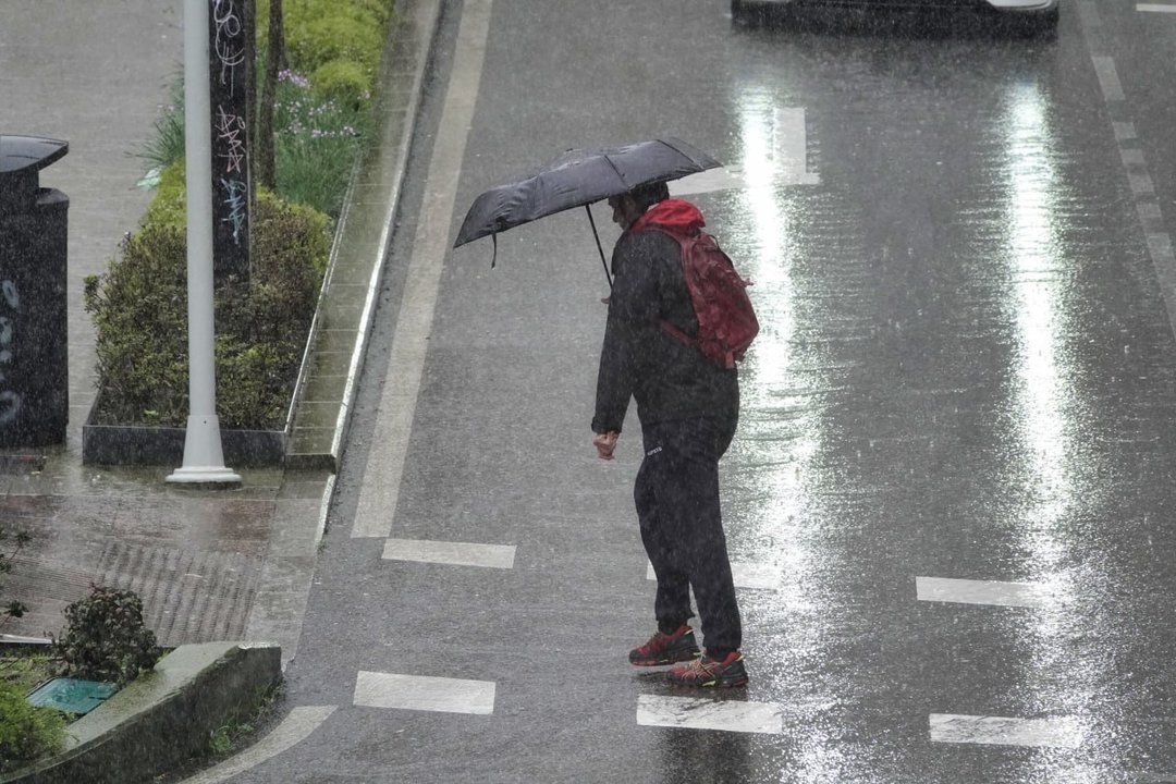 Una persona camina bajo la lluvia con su paraguas por Vigo. // Vicente Alonso