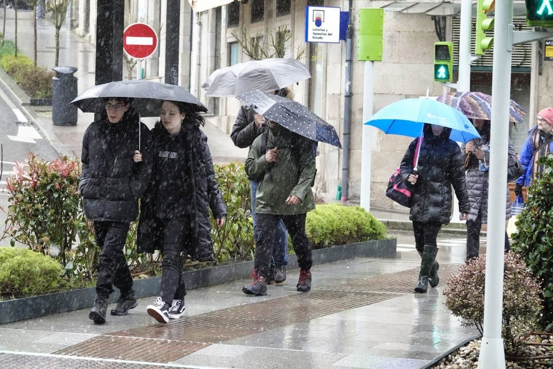 Ciudadanos caminando bajo la lluvia en Vigo. // Vicente Alonso