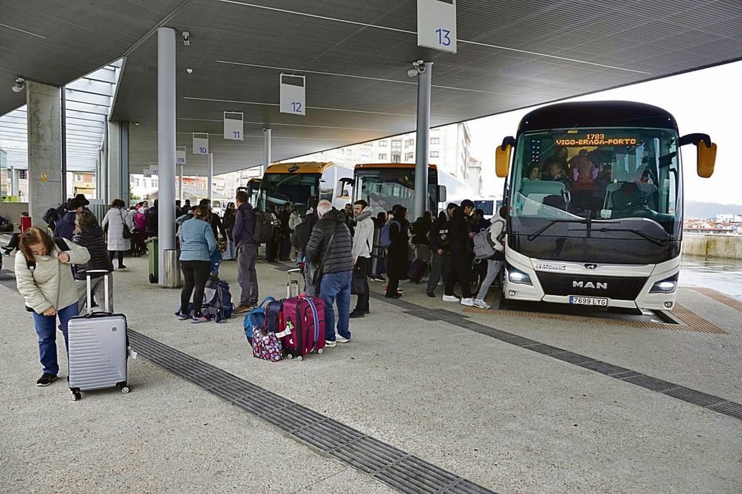 Un autobús que viaja a Oporto, estacionado en la estación de autobuses de Urzaiz mientras se suben usuarios.