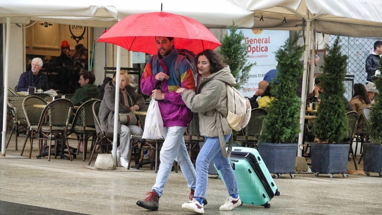 Dos personas se protegen de la lluvia en Porta do Sol.